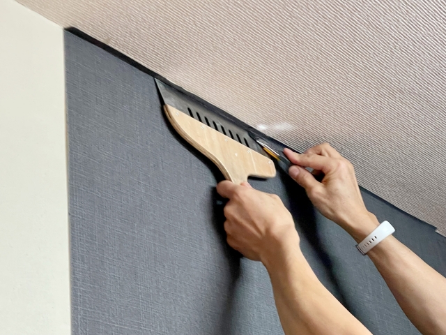 室内の壁紙を貼り直している手元