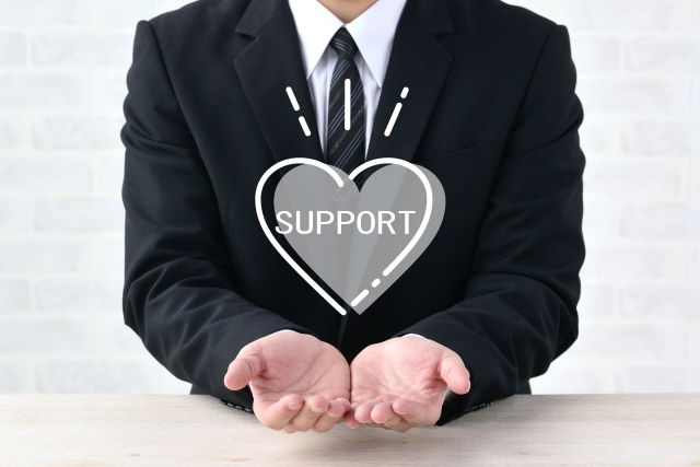 SUPPORTの文字列を手のひらに乗せるビジネスマン